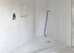 Modern shower featuring white marble tile with grey accent.
