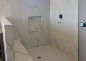 Shower Design featuring white marble tile with matching bench seat.